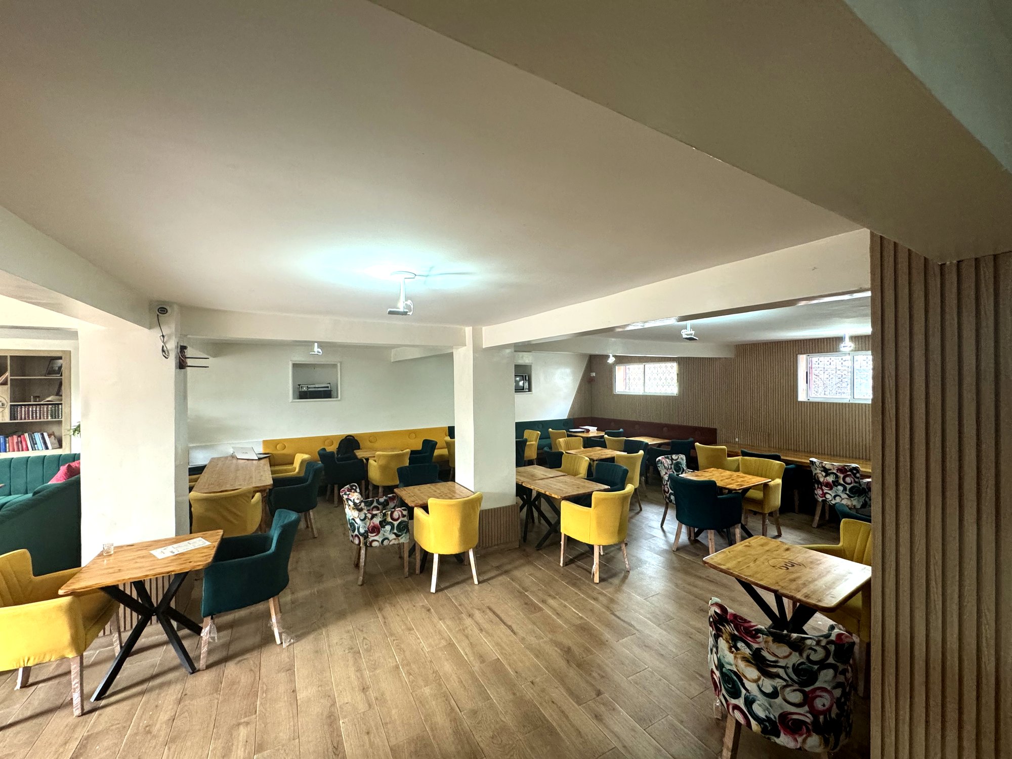 Salle intérieure avec fauteuils verts et jaunes, ambiance chaleureuse